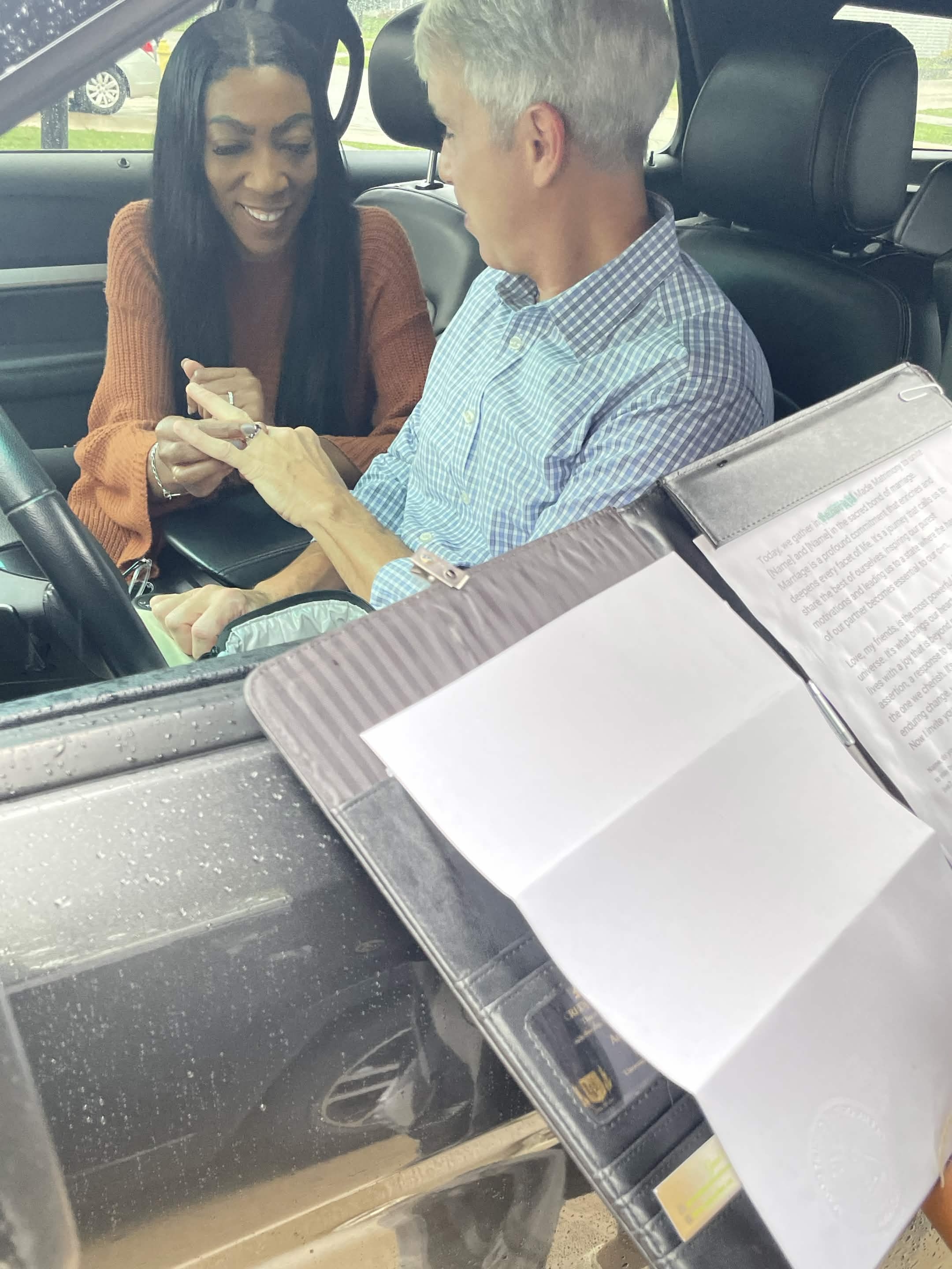 A couple exchanging rings at a drive-thru wedding