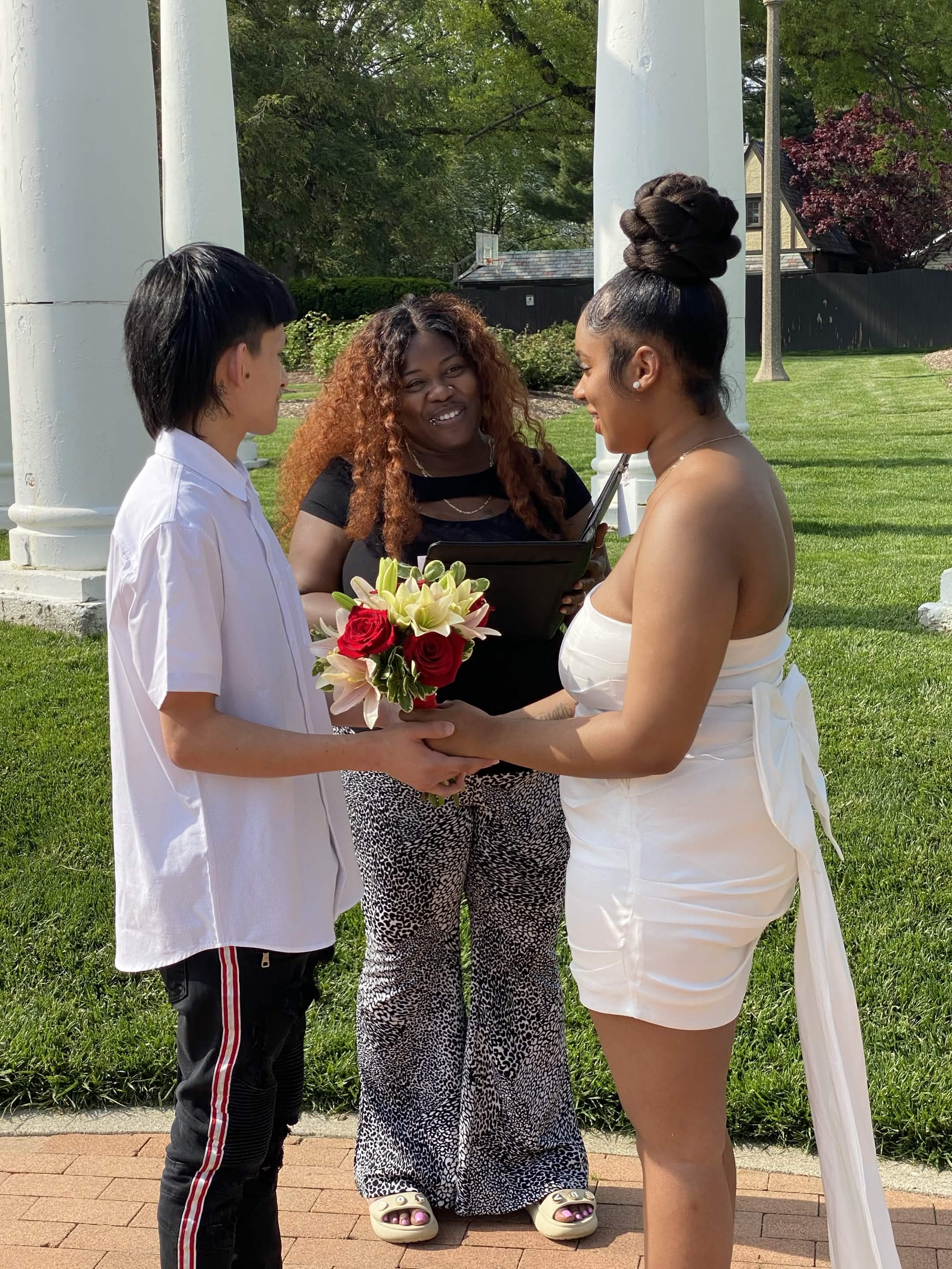 Angelica marrying a couple holding a rose bouquet